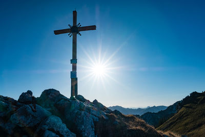 Sunstar at a summit cross in the bavarian alps.