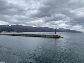 Lighthouse by sea against sky
