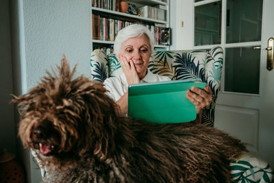 Portrait of woman with dog at home