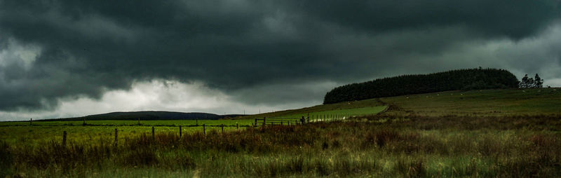 Scenic view of green landscape against cloudy sky
