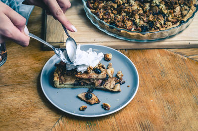 A piece of sweet cake with nuts, apples on a blue plate