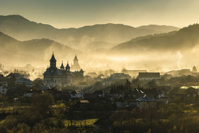 Panoramic view of buildings and mountains against sky