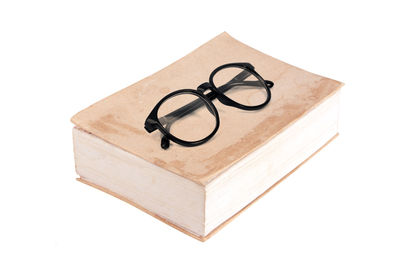 Close-up of eyeglasses on paper against white background