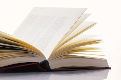 Close-up of open book on table against white background