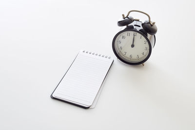 Close-up of clock on table against white background