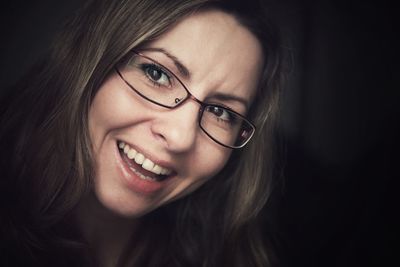 Close-up of happy woman wearing eyeglasses while looking away