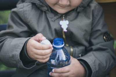 Midsection of girl holding water bottle