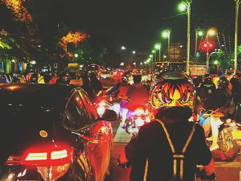 People walking on illuminated street at night