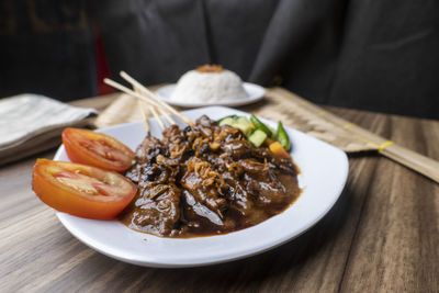 Sate ayam, satays with peanut sauce, famous indonesian cuisine photographed with high angle view