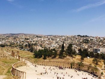 Panoramic view of people on mountain against clear blue sky
