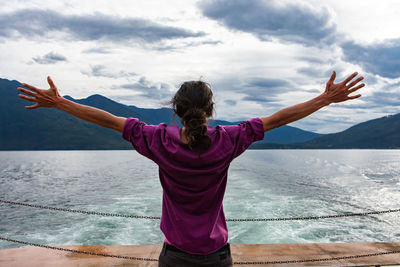 Rear view of woman looking at sea against sky