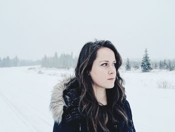Woman standing on snow covered field