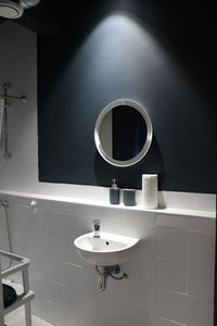 Round mirror and sink in spotlight 