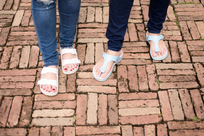 Low section of women standing on footpath