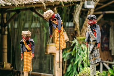 Toys hanging on wooden poles against house