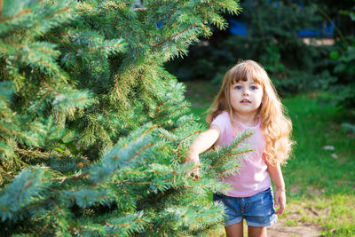 Full length of girl standing against trees