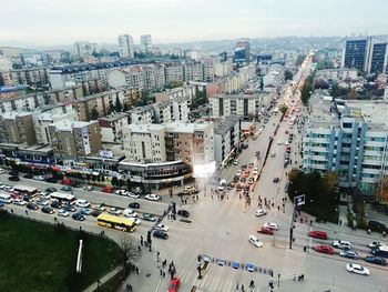 High angle view of vehicles on road by buildings in city