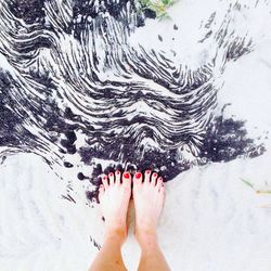 Low section of woman walking on beach