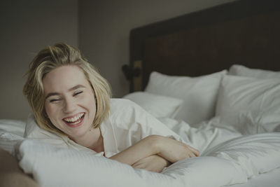 Blond woman laughing in bedroom