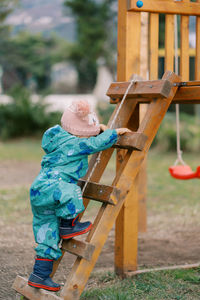 Full length of boy sitting on slide