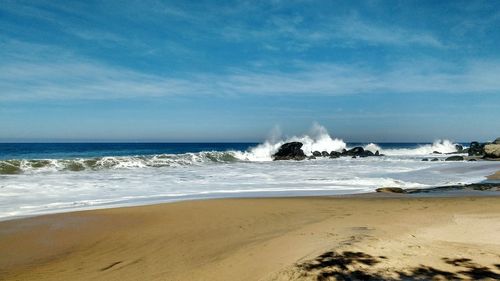 Scenic view of beach against blue sky