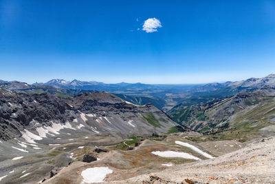 Scenic view of landscape and mountains against blue sky