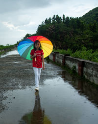 Rear view of woman holding umbrella