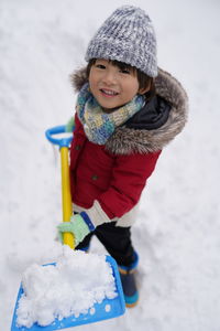 Portrait of smiling boy standing on snow