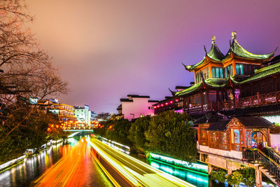 Illuminated buildings against sky at night