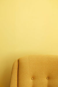 Yellow sofa against wall at home