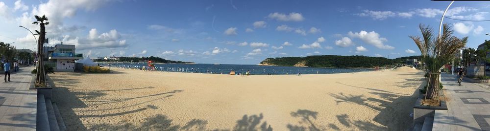 Panoramic view of calm beach against blue sky