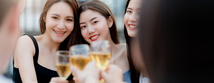 Portrait of smiling young woman holding drinking glass