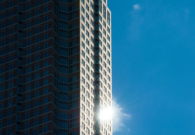 Low angle view of modern building against blue sky