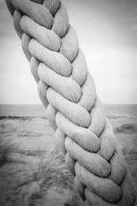 Close-up of rope tied to sea against sky