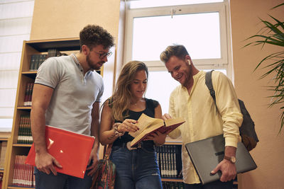 Young couple holding book at home