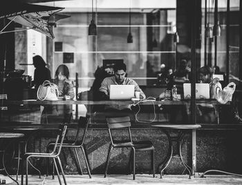 People sitting in cafe seen through glass window