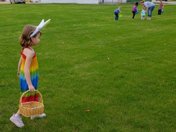 Girl with basket walking on field