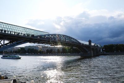 Bridge over river against sky in city