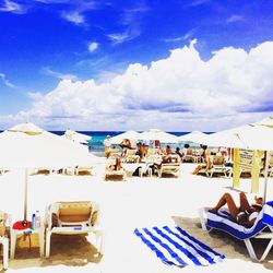 Empty chairs and tables against blue sky