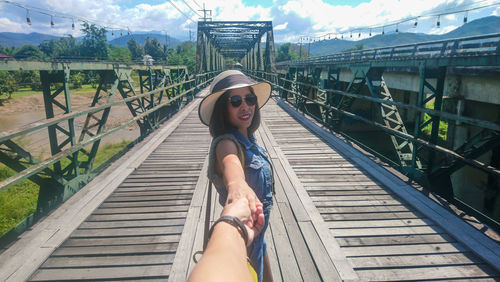 Woman in sunglasses on footbridge