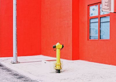 Close-up of fire hydrant against red building