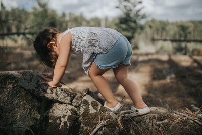 Side view of child on rock