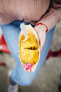 Top view of woman holding stuffed potatoes with onion and sauce. street food. foodtruck. 