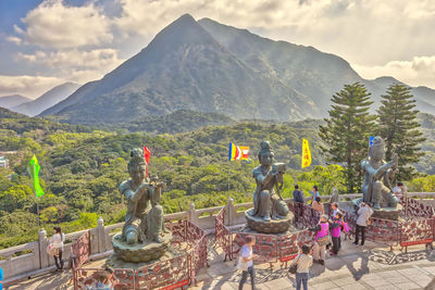 Statue against temple and mountains against sky