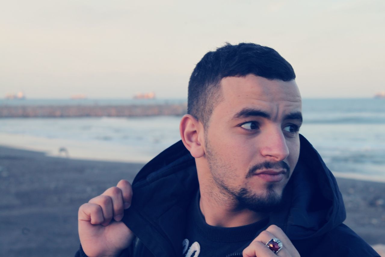 lifestyles, young men, person, headshot, beach, young adult, leisure activity, portrait, focus on foreground, looking at camera, water, sea, mid adult men, casual clothing, front view, sunglasses, head and shoulders, clear sky