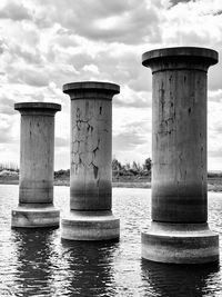 View of wooden post in sea against sky