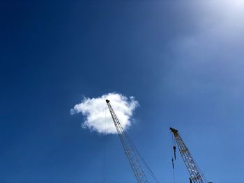 Low angle view of ferris wheel against blue sky