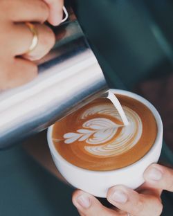 Close-up of hand holding coffee cup