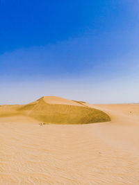 Scenic view of desert against clear blue sky