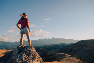 Full length of woman standing on mountain against clear sky
